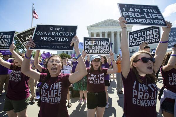 FILE - In this June 25, 2018 file photo, pro-life and anti-abortion advocates demonstrate in front of the Supreme Court in Washington. Republican lawmakers in at least a half dozen GOP-controlled states already are talking about copying a Texas law that bans abortions after a fetal heartbeat is detected. The law was written in a way that was intended to avoid running afoul of federal law by allowing enforcement by private citizens, not government officials.  (AP Photo/J. Scott Applewhite, File)