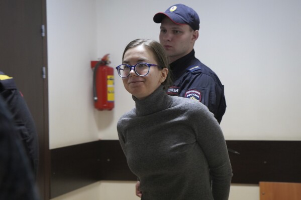 Viktoria Petrova is escorted by police for a hearing in a court in St. Petersburg, Russia, Friday, March 3, 2023. (AP Photo)