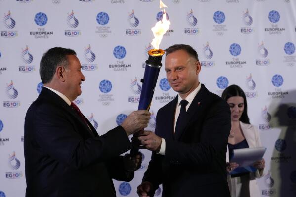 Polish President Andrzej Duda, right, receives the Flame of Peace from President of the European Olympic Committee (EOC) Spyros Capralos during the handover ceremony for the European Games of Krakow-Malopolska 2023 at Rome's Ara Pacis museum, Italy, Monday, April 3, 2023. (AP Photo/Alessandra Tarantino)