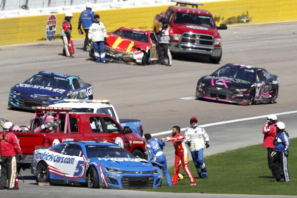 Bubba Wallace, center right, shoves Kyle Larson (5) after they crashed during a NASCAR Cup Series auto race at Las Vegas Motor Speedway in Las Vegas, Sunday, Oct. 16, 2022. (Steve Marcus/Las Vegas Sun via AP)