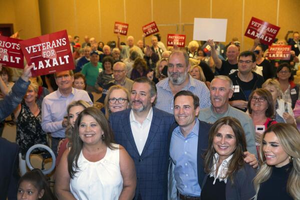 U.S. Sen. Ted Cruz, center left, R-Texas, and Republican Nevada Senate candidate Adam Laxalt, center right, pose with Laxalt supporters during a campaign event at Sun City Anthem Center in Henderson, Nev., Friday, April 22, 2022. (Steve Marcus/Las Vegas Sun via AP)