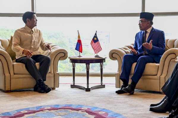 In this handout photo provided by the Jabatan Penerangan Malaysia/ Department of Information Malaysia, Malaysia Prime Minister Anwar Ibrahim, right, talks with Philippine President Ferdinand Marcos Jr., in Putrajaya, Malaysia on Wednesday July 26, 2023. (Jabatan Penerangan Malaysia/ Department of Information Malaysia via AP)