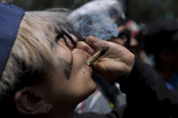 
              FILE - In this April 20, 2018 file photo,  a young man smokes marijuana to celebrate the International Day for Cannabis in Mexico City. Mexico’s Supreme Court issued two more rulings Wednesday, Oct. 31, ordering that complainants in individual cases be allowed to use marijuana for recreational purposes, establishing a precedent which will apply for others that a blanket prohibition is unconstitutional. (AP Photo/Eduardo Verdugo, File)
            