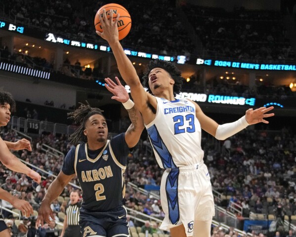 Creighton's Trey Alexander (23) goes for a lay up against Akron's Greg Tribble (2) during the first half of a college basketball game in the first round of the NCAA men's tournament in Pittsburgh, Thursday, March 21, 2024. (AP Photo/Gene J. Puskar)