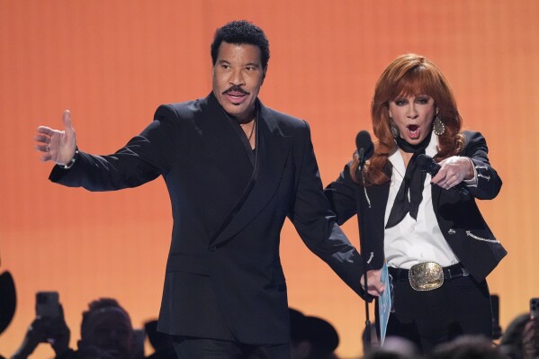 Host Reba McEntire, right, introduces Lionel Richie during the 60th annual Academy of Country Music Awards on Thursday, May 8, 2025, in Frisco, Texas. (AP Photo/Chris Pizzello)
