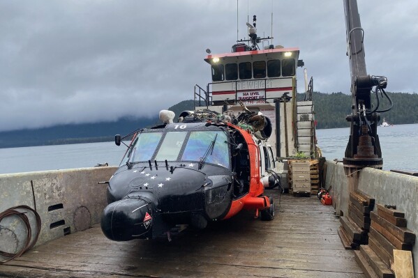 This image provided by the U.S. Coast Guard District 17 PADET Anchorage shows a U.S. Coast Guard MH-60 Jayhawk helicopter from Air Station Sitka on a boat after being recovered from the site of a crash near Read Island, Alaska, Friday, Dec. 8, 2023. The four crew members involved in the Nov. 13 crash survived. (Air Station Sitka/U.S. Coast Guard via AP)