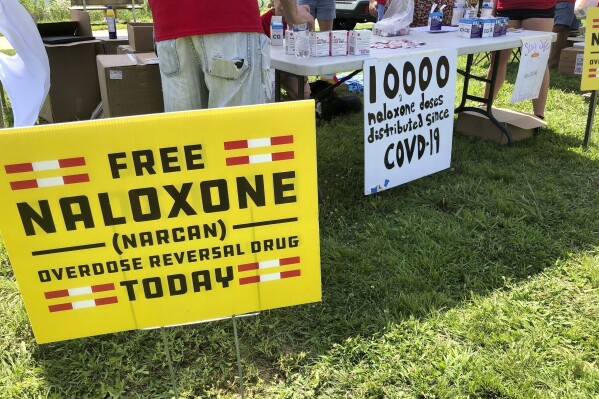 Signs are displayed at a tent during a health event on June 26, 2021, in Charleston, W.Va. (AP Photo/John Raby, File)