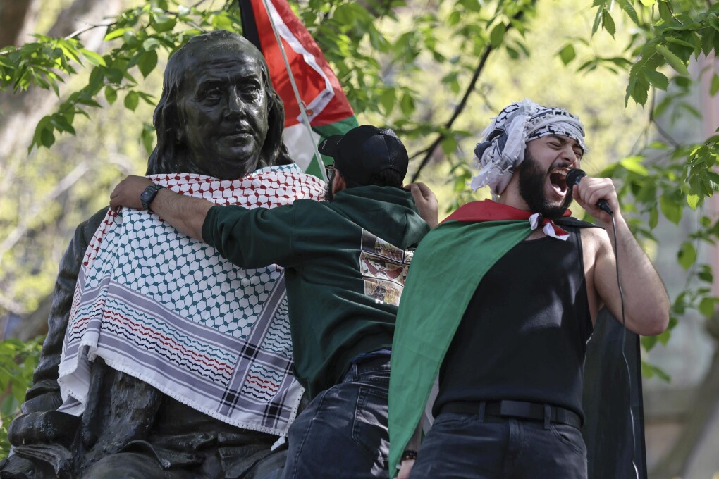 Qais Dana protests as a person puts a scarf on a Ben Franklin statue on Penn's campus during a pro-Palestinian demonstration in Philadelphia on Thursday, April 25, 2024. (Elizabeth Robertson/The Philadelphia Inquirer via AP)