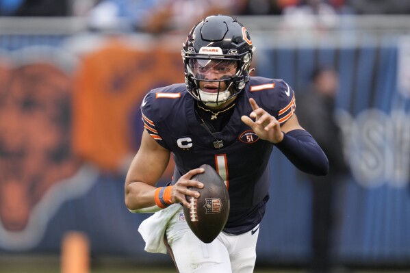 Chicago Bears quarterback Justin Fields signals to a teammate during the first half of an NFL football game against the Detroit Lions Sunday, Dec. 10, 2023, in Chicago. (AP Photo/Erin Hooley)