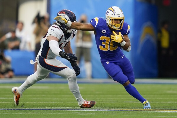 Los Angeles Chargers running back Austin Ekeler (30) runs with the ball as Denver Broncos linebacker Alex Singleton (49) defends during the first half of an NFL football game Sunday, Dec. 10, 2023, in Inglewood, Calif. (AP Photo/Ryan Sun)