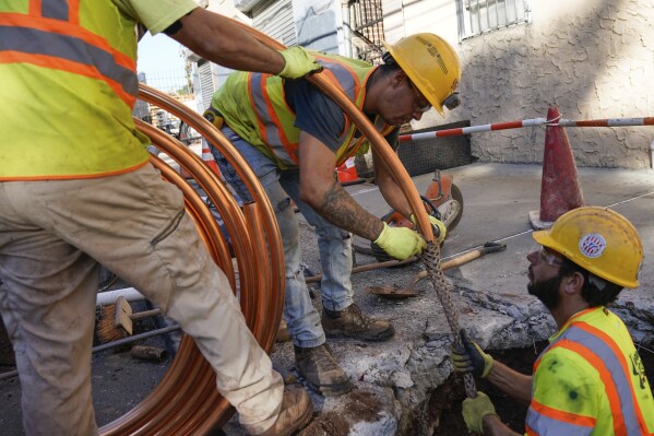FILE - Workmen prepare to replace older water pipes with a new copper one in Newark, N.J., Oct. 21, 2021. (AP Photo/Seth Wenig, File)