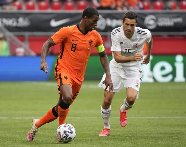 Netherlands' Georginio Wijnaldum, left, and Georgia's Giorgi Aburjania vie for the ball during the friendly soccer match between The Netherlands and Georgia, in the run-up to the Euro2020 soccer tournament, in Enschede, eastern Netherlands, Sunday, June 6, 2021. (AP Photo/Peter Dejong)
