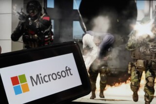 The logo for Microsoft, and a scene from Activision "Call of Duty - Modern Warfare," are shown in this photo, in New York, Wednesday, June 21, 2023. Microsoft reports earnings on Tuesday July 25, 2023. (AP Photo/Richard Drew, File)