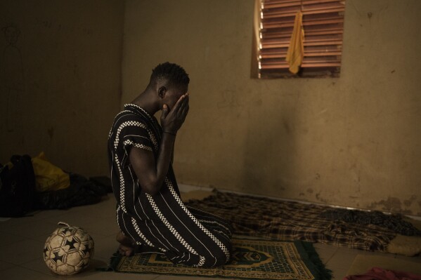 Papa Dieye, de 19 años, reza en la casa de su padre en Diogo, Senegal, el lunes 28 de agosto de 2023. (AP Foto /Felipe Dana)   