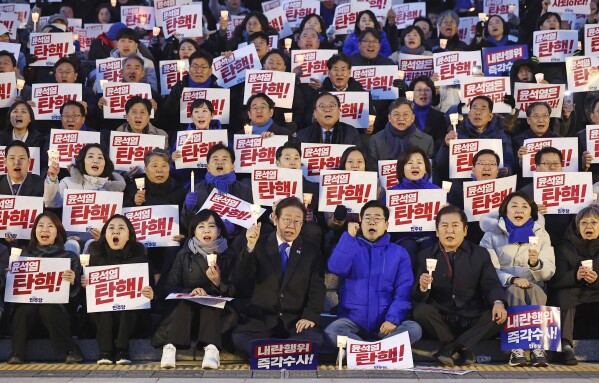 South Korea's main opposition Democratic Party leader Lee Jae-myung, bottom center left, and his party members stage a rally against the President Yoon Suk Yeol at the National Assembly in Seoul, South Korea, Wednesday, Dec. 4, 2024. The signs read 