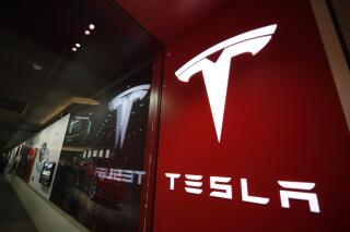 FILE - This Feb. 9, 2019, file photo shows a sign bearing the company logo outside a Tesla store in Cherry Creek Mall in Denver. U.S. auto safety regulators are looking into a complaint from a Tesla driver that the company’s “Full Self-Driving” software caused a crash. The complaint says the vehicle, a 2021 Tesla Model Y small SUV, gave the driver an alert halfway through the turn, and the driver tried to turn the wheel to avoid other traffic. (AP Photo/David Zalubowski, File)