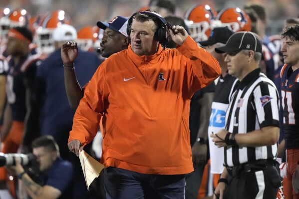 Illinois head coach Brett Bielema, center, walks the sideline during the second half of an NCAA college football game against Toledo, Saturday, Sept. 2, 2023, in Champaign, Ill. (AP Photo/Charles Rex Arbogast)