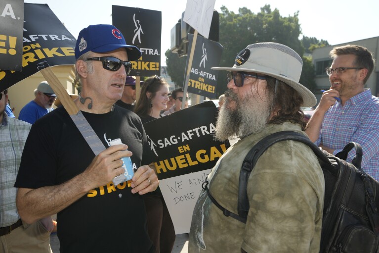 Actors Bob Odenkirk, left, and Jack Black, right, join demonstrators outside the Paramount Pictures Studio in Los Angeles, Tuesday, Sept. 26, 2023. (AP Photo/Damian Dovarganes)