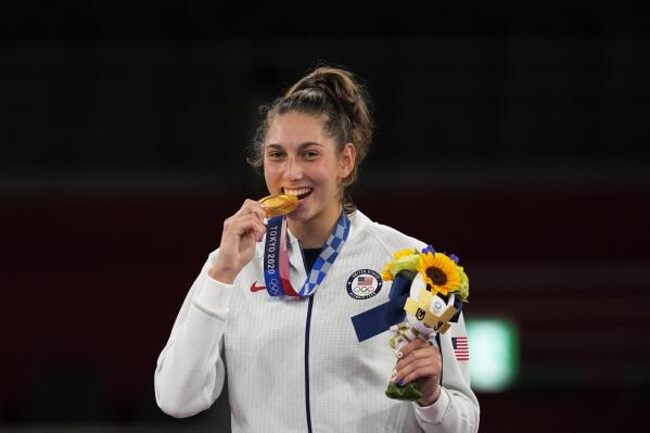 United States's Anastasija Zolotic holds her gold medal during a ceremony for the taekwondo women's 57kg at the 2020 Summer Olympics, Sunday, July 25, 2021, in Tokyo, Japan. (AP Photo/Themba Hadebe)
