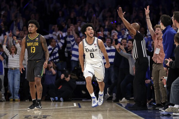Duke guard Jared McCain (0) reacts after making a 3-point basket, next to Baylor guard Langston Love during the second half of an NCAA college basketball game Wednesday, Dec. 20, 2023, in New York. (AP Photo/Adam Hunger)