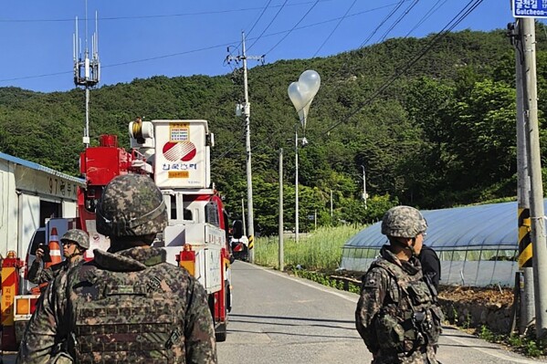 FILE - In this photo provided by Jeonbuk Fire Headquarters, balloons with trash presumably sent by North Korea, hang on electric wires as South Korean army soldiers stand guard in Muju, South Korea, on Wednesday, May 29, 2024. (Jeonbuk Fire Headquarters via AP, File)