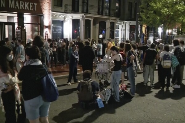 In this grab taken from video, protestors protesting the Israel-Hamas war stand outside near the campus of George Washington University, in Washington, Wednesday, May 8, 2024. Tensions have continued to ratchet up in standoffs with protesters on campuses across the U.S. and increasingly, in Europe, nearly three weeks into a movement launched by a protest at Columbia University. (WJLA via AP)