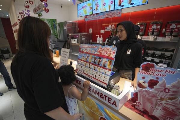 A costumer orders a drink at a Mixue store in Jakarta, Indonesia, Wednesday, Feb. 19, 2025. (AP Photo/Achmad Ibrahim)
