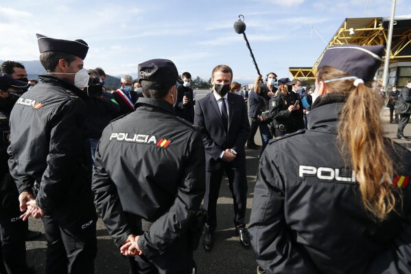 French President Emmanuel Macron greets Spanish police officers during a visit on the strengthening border controls at the crossing between Spain and France, at Le Perthus, France, Thursday, Nov. 5, 2020. (Guillaume Horcajuelo, Pool via AP)