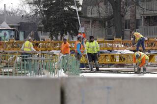 FILE- Road construction workers work on Buffalo Grove Road in Buffalo Grove, Ill., Thursday, Nov. 19, 2020. Illinois' governor wants to provide some relief to pocketbook-pinched consumers. Gas averages $3.60 per gallon and inflation is at its highest rate since 1982. Gov. J.B. Pritzker, a Democrat facing reelection this year, has proposed freezing the motor fuel tax, which is scheduled to jump 2 cents on July 1. (AP Photo/Nam Y. Huh)