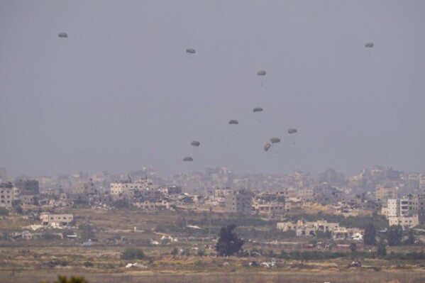 Parachutes drop supplies into the northern Gaza Strip, seen from southern Israel, Monday, April 15, 2024. (AP Photo/Ohad Zwigenberg)