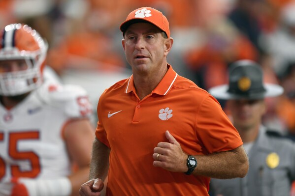 FILE -Clemson head coach Dabo Swinney runs on the field during the first half of an NCAA college football game against Syracuse in Syracuse, N.Y., Saturday, Sept. 30, 2023. Clemson has opened spring football practice Wednesday, Feb. 28, 2024 with Swinney eager to build on the Tigers' finish of five straight victories. (APPhoto/Adrian Kraus, File)