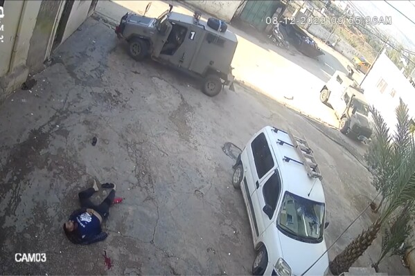 This image taken from video taken on Dec 8, 2023, in the Faraa refuge camp shows soldiers shooting down the men at close range when they did not appear to pose a threat. Security footage obtained by the Israeli human rights group B'Tselem shows two Israeli soldiers pursuing shooting the men — one while he was incapacitated and the other appearing to be unarmed — during a raid in a West Bank refugee camp. (B'Tselem via AP)