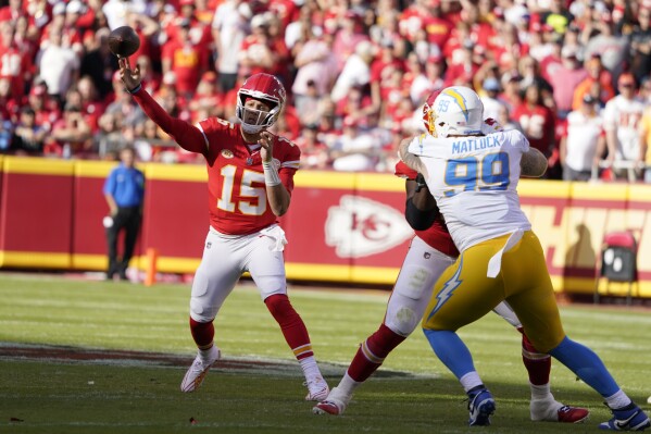 Kansas City Chiefs quarterback Patrick Mahomes (15) throws as Los Angeles Chargers defensive tackle Scott Matlock (99) defends during the first half of an NFL football game Sunday, Oct. 22, 2023, in Kansas City, Mo. (AP Photo/Ed Zurga)