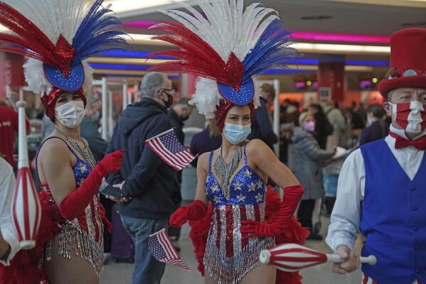 Performers entertain passengers at London Heathrow Airport's T3 as the US reopens its borders to UK visitors in a significant boost to the travel sector, in London, Monday, Nov. 8, 2021. (Steve Parsons/PA via AP)