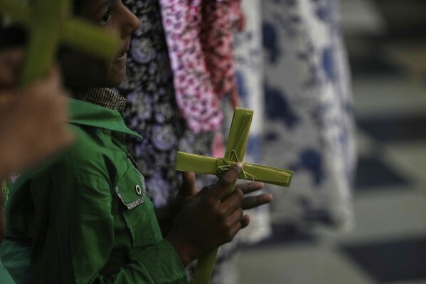 A Catholic holds cross made of blessed palm leaves during a Palm Sunday mass at Mariarani Cathedral in Nalgonda, Telangana State, India, Sunday, April 13, 2025. Palm Sunday marks the sixth and last Sunday of the Christian Holy month of Lent. (AP Photo/Mahesh Kumar A.)
