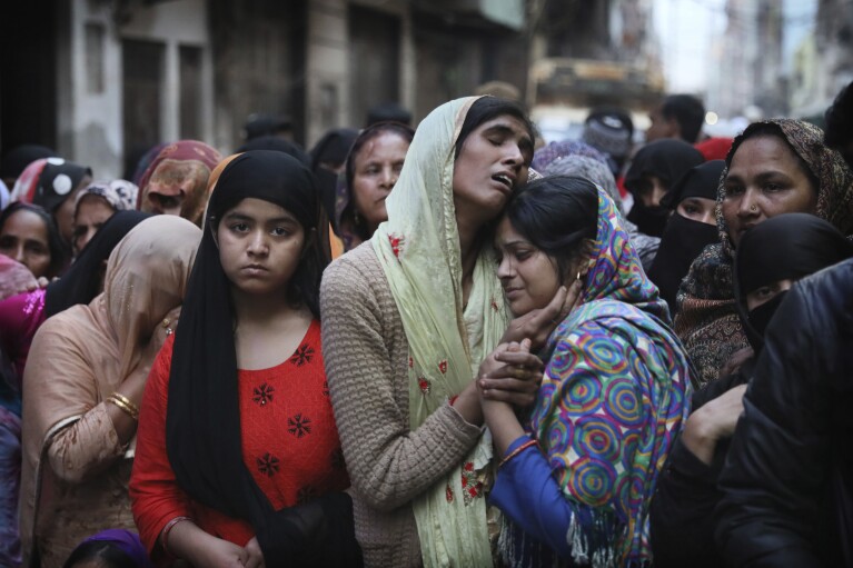 FILE- Relatives and neighbors mourn after a man was killed during violent clashes between Hindus and Muslims in New Delhi, India, Feb. 27, 2020. (AP Photo/Manish Swarup, File)