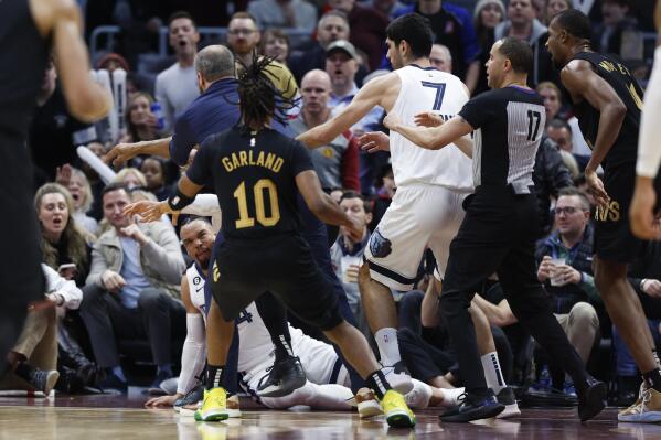 Memphis Grizzlies forward Dillon Brooks lays on the ground during a fight with Cleveland Cavaliers guard Donovan Mitchell (45) during the second half of an NBA basketball game, Thursday, Feb. 2, 2023, in Cleveland. Mitchell and Brooks were ejected from the game. (AP Photo/Ron Schwane)