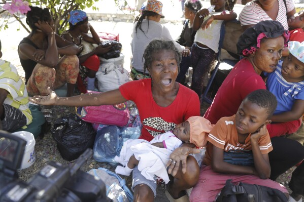 Women and children gather outside a police station after fleeing their homes in Cite Soleil due to gang violence, in Port-au-Prince, Haiti, Monday, Feb. 12, 2024. (APPhoto/Odelyn Joseph)