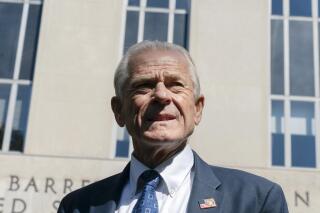 FILE - Former White House trade adviser Peter Navarro listens as his legal team talk to members of the media outside the federal court in Washington, Aug. 31, 2022. Navarro is scheduled to stand trial in September on contempt of Congress charges filed after he refused to cooperate with a congressional investigation into the Jan. 6 attack on the U.S. Capitol. A judge set the September 5 trial date on Tuesday. (AP Photo/Manuel Balce Ceneta, File)