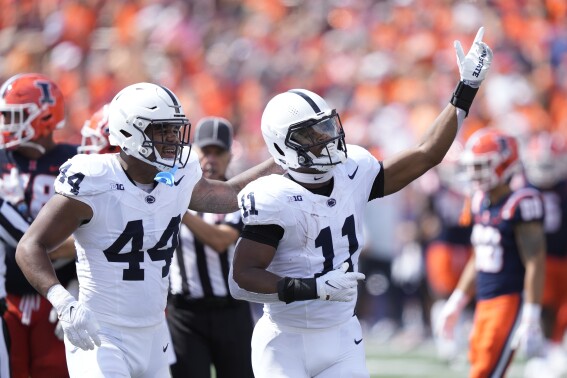 Penn State linebacker Abdul Carter (11) celebrates his interception with Chop Robinson during the first half of an NCAA college football game against Illinois, Saturday, Sept. 16, 2023, in Champaign, Ill. (AP Photo/Charles Rex Arbogast)