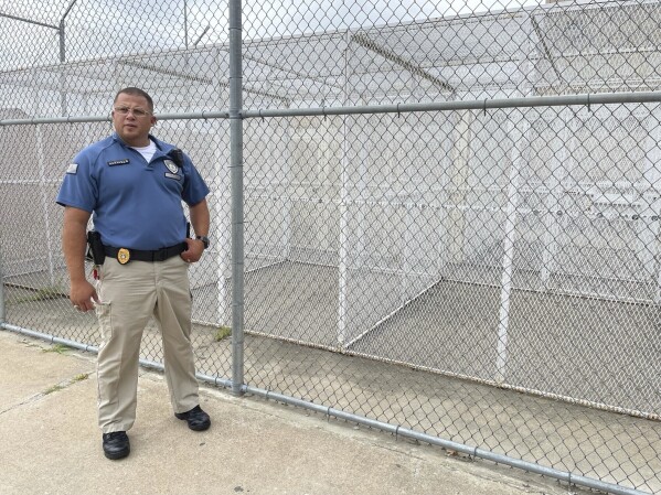 Maj. Albin Narvaez stands near a series of outdoor recreation cages used for prisoners who are in administrative segregation at the Fulton Reception and Diagnostic Center, Thursday, July 13, 2023, in Fulton, Mo. Narvaez, who is chief of custody at the prison, said applications for correctional officers have increased since the state implemented a pay raise this spring. (AP Photo/David A. Lieb)