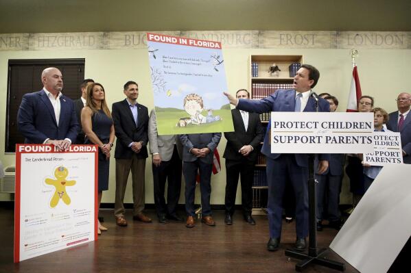 Florida Gov. Ron DeSantis shows an image from the children's book Call Me Max by transgender author Kyle Lukoff moments before signing the Parental Rights in Education bill during a news conference on Monday, March 28, 2022, at Classical Preparatory school in Shady Hills. At left is an image of The Genderbread Person, a teaching tool used for breaking the concept of gender. (Douglas R. Clifford/Tampa Bay Times via AP)