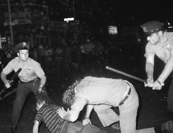 FILE- In this Aug. 31,1970 file photo, an NYPD officer grabs a youth by the hair as another officer clubs a young man during a confrontation in Greenwich Village after a demonstration march in New York. (AP Photo/File)