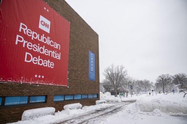 Signs are displayed ahead of the Republican presidential debate at Drake University in Des Moines, Iowa, Tuesday, Jan. 9, 2024. (AP Photo/Andrew Harnik)