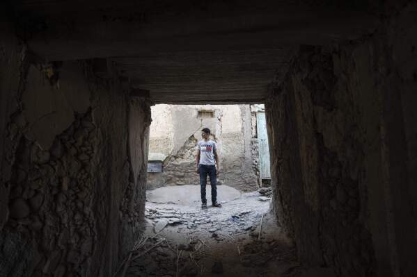 A man walks through the wreckage of his that was caused by the September earthquake, in Moulay Ibrahim, outside Marrakech, Morocco, Friday, Oct. 6, 2023. Morocco has pledged to rebuild from a September earthquake in line with its architectural heritage. Villagers and architects agree that earthquake-safe construction is a top priority. That’s created a push for modern building materials. But the government says it wants to rebuild in line with Morocco’s cultural and architectural heritage. (AP Photo/Mosa'ab Elshamy)