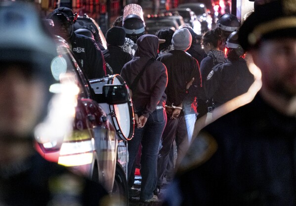 New York City police officers take people into custody near the Columbia University campus in New York Tuesday, April 30, 2024, after a building taken over by protesters earlier in the day was cleared, along with a tent encampment. (AP Photo/Craig Ruttle)