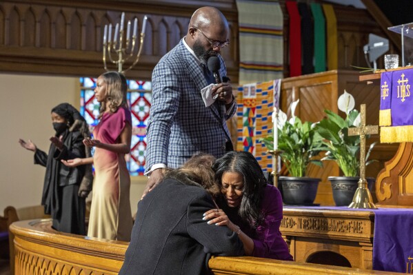 Rev. William H. Lamar IV, top, and Rev. Cozette Thomas, right, pray with a parishioner during Palm Sunday services at the Metropolitan AME Church in Washington, Sunday, March 24, 2024. Lamar says their churches are still feeling the pandemic’s impact on attendance, even as they have rolled out robust online worship options to reach people. (AP Photo/Amanda Andrade-Rhoades)