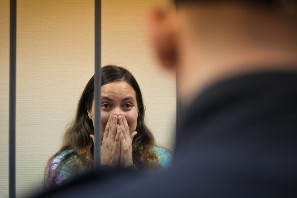 Sasha Skochilenko, a 33 year-old artist and musician cries standing behind bars in the court room in the Vasileostrovsky district court in St. Petersburg, Russia, Thursday, Nov. 16, 2023. Skochilenko has been convicted of spreading false information about the military and sentenced to 7 years in prison after replacing several supermarket price tags with slogans criticizing Russia's military action in Ukraine. (AP Photo/Dmitri Lovetsky)