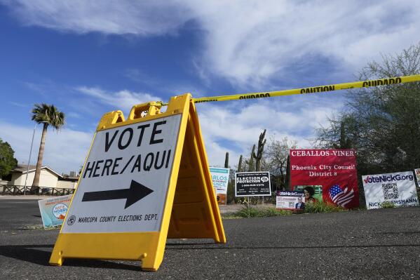 FILE - A voting sign points voters in the right direction to drop off ballots in Phoenix, Monday, Nov. 7, 2022. On Friday, Nov. 18, The Associated Press reported on stories circulating online incorrectly claiming the fact that incumbent Republican state treasurer Kimberly Yee got tens of thousands more votes than GOP gubernatorial candidate Kari Lake shows the Arizona election was rigged.  (AP Photo/Ross D. Franklin, File)