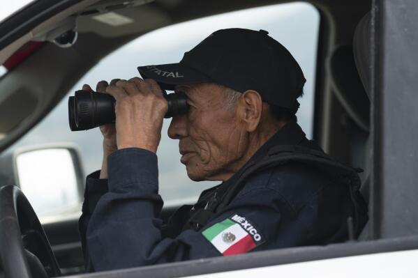 Nefi de Aquino, who works as a police officer and is also paid to keep an eye on the activity of the Popocatépetl volcano, looks at the volcano through his binoculars from Santiago Xalitzintla, Mexico, Thursday, 25 May 2023. De Aquino has been observing and reporting on the volcano´s activity since it started erupting again in 1994. (AP Photo/Marco Ugarte)